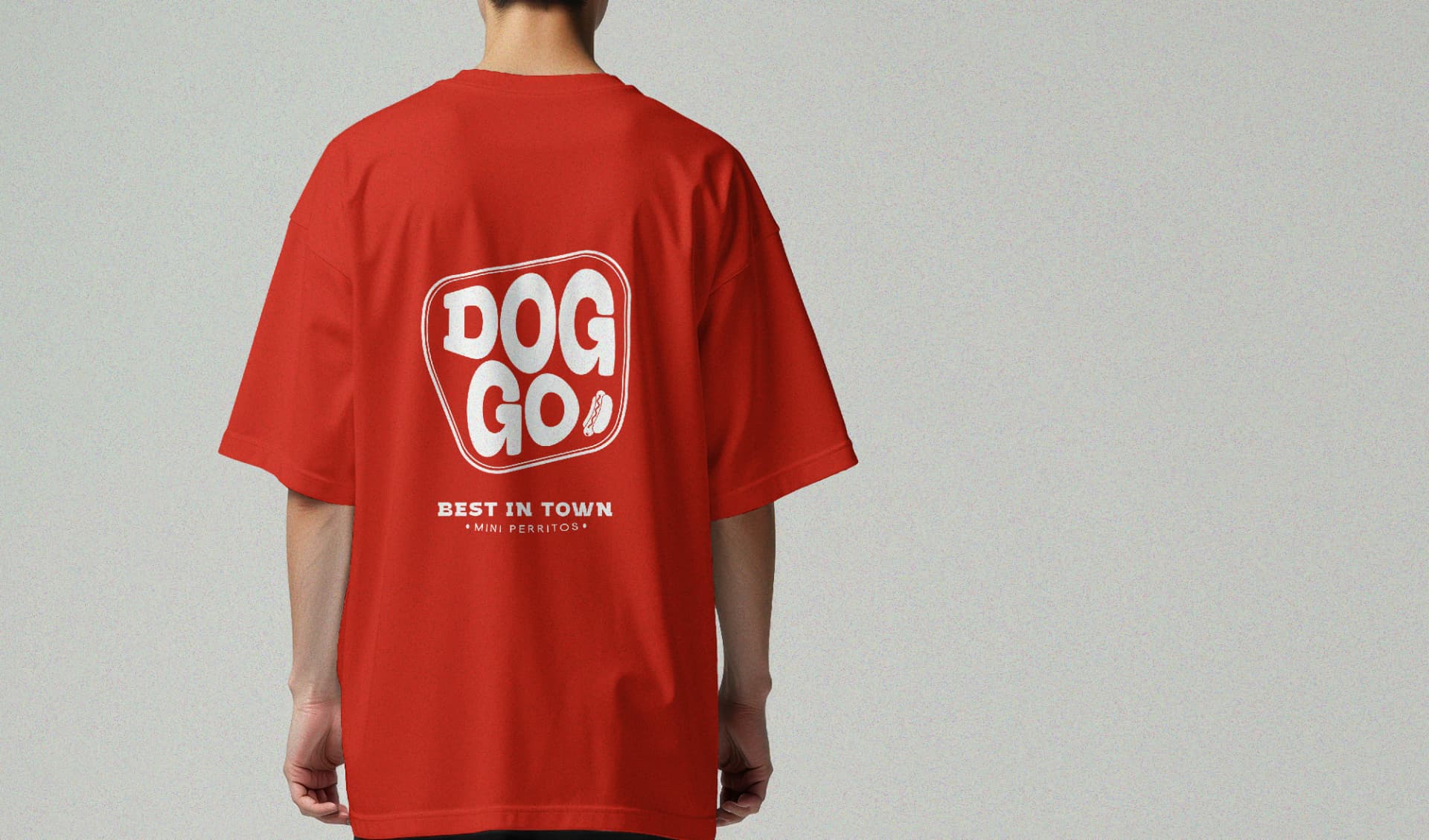 Persona de espaldas con camiseta roja que lleva el logotipo DOGGO impreso en blanco