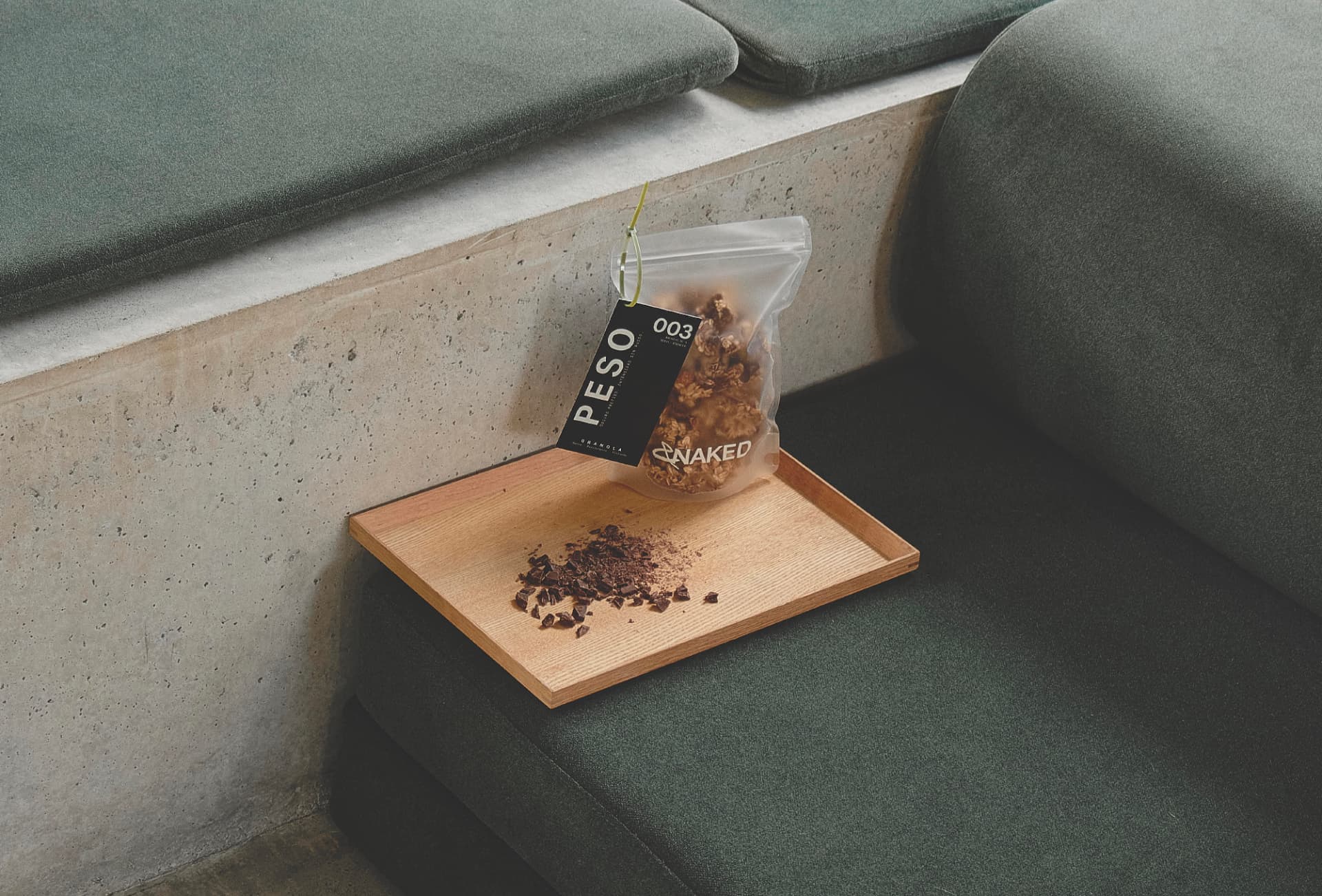 Granola &NAKED Peso sobre una bandeja de madera y asiento verde