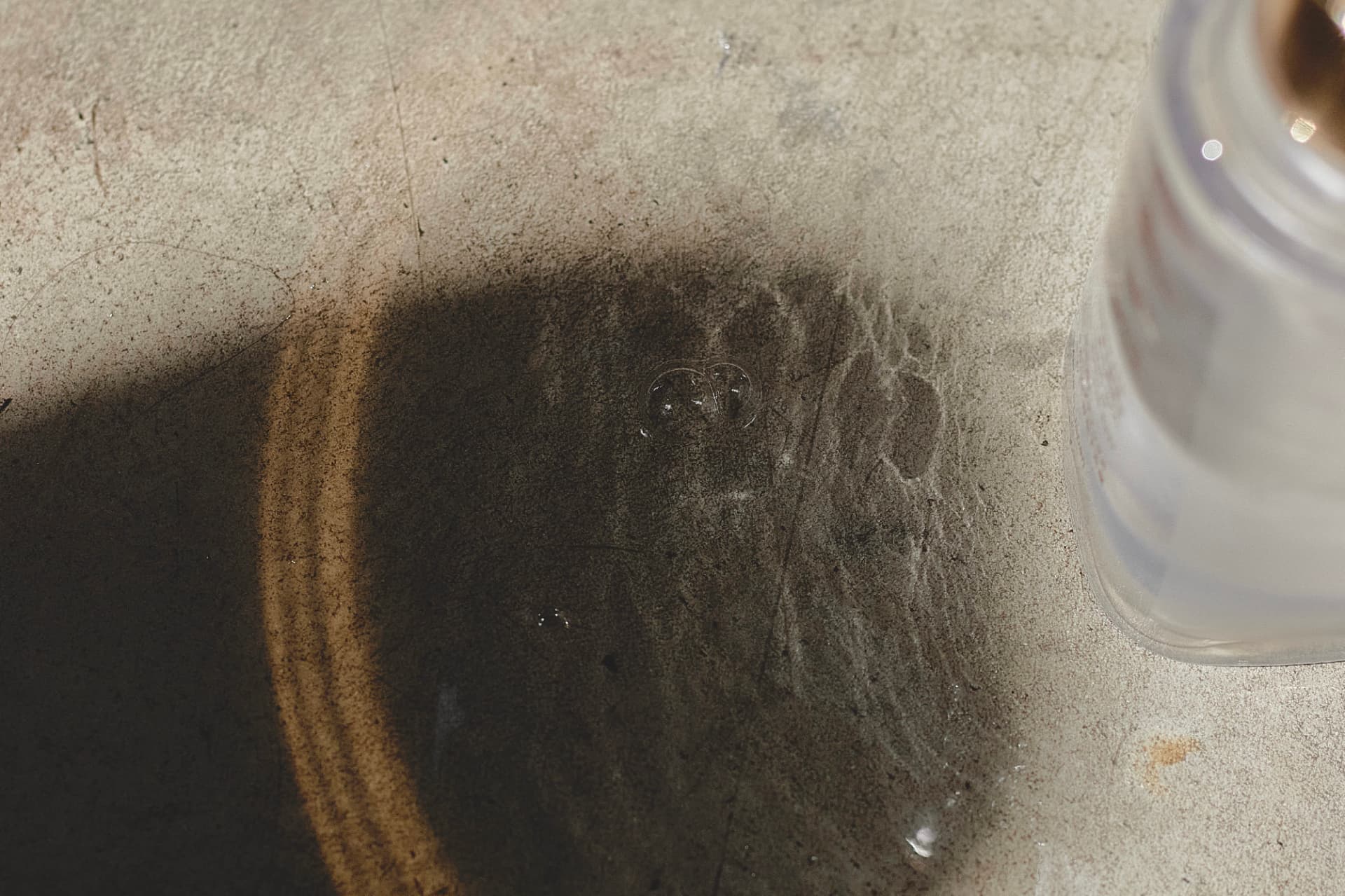 Detalle de gotas del sérum sobre una superficie de concreto