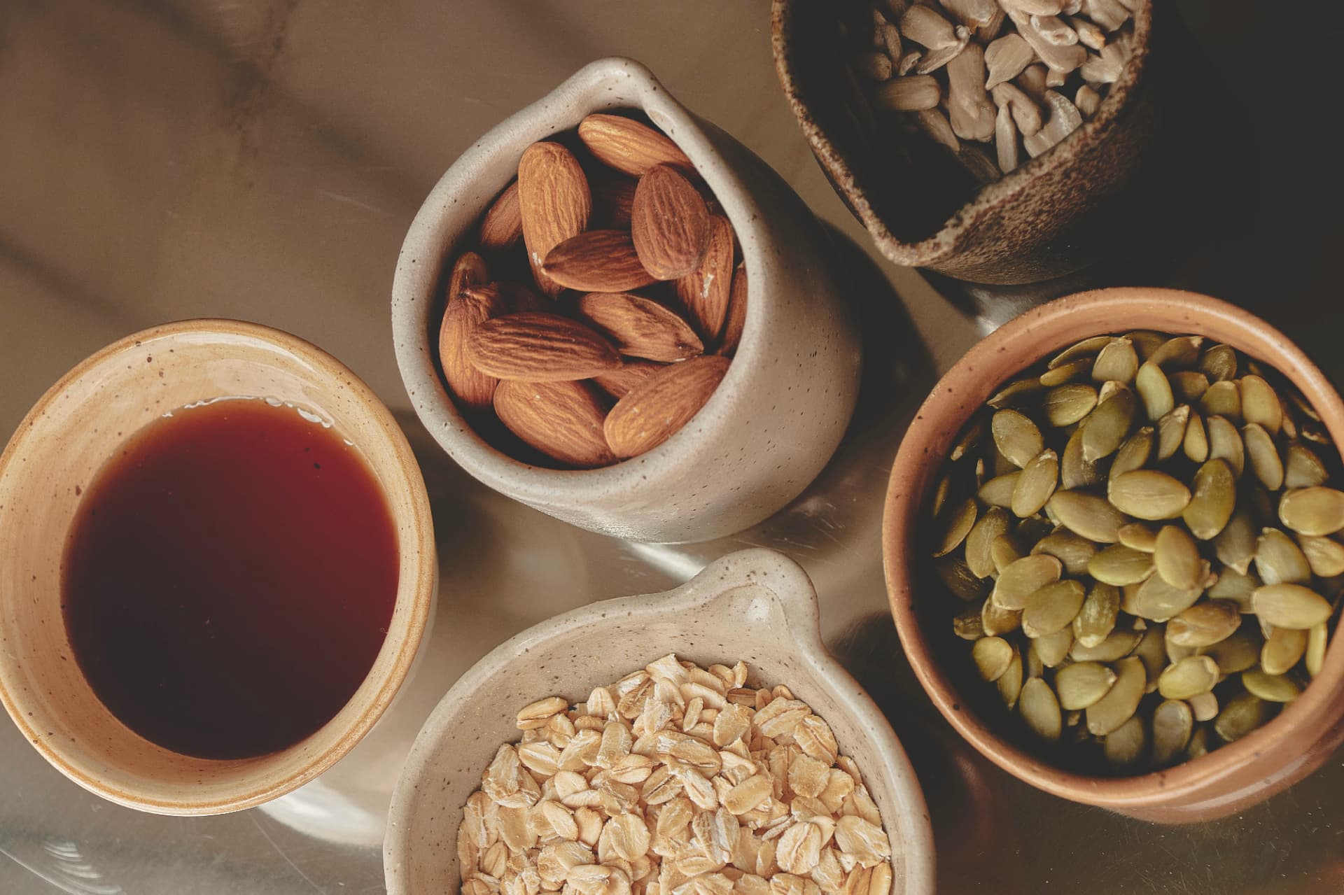 Ingredientes de granola en recipientes de cerámica