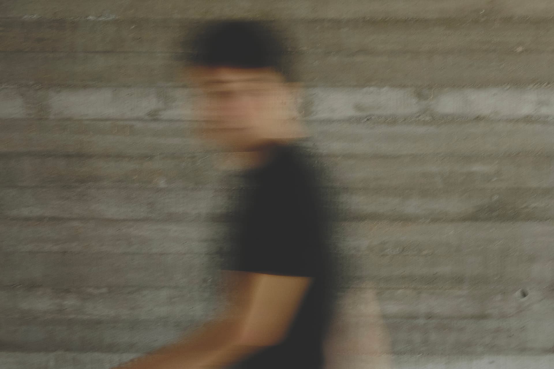 Persona en movimiento frente a una pared de concreto